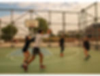 Friends having playing a game of pickup basketball, full of energy and smiling.